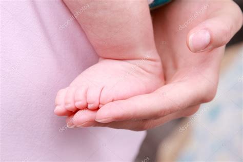 Крупный план ножки новорожденного в руках мамочки #11318336 - Ларасток