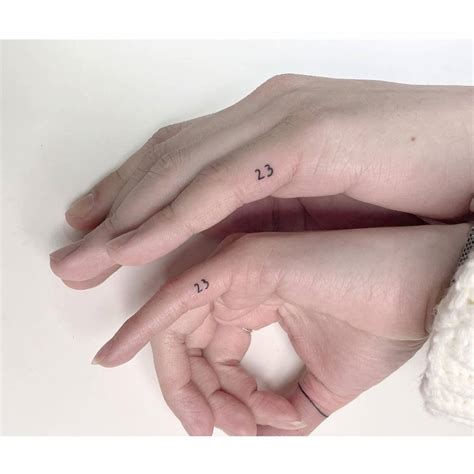 Matching tattoo of the number "23" for couple.