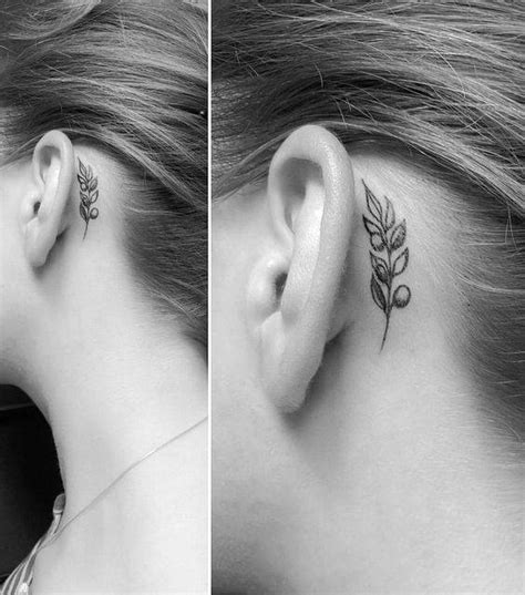 Olive branch tattoo behind the ear.